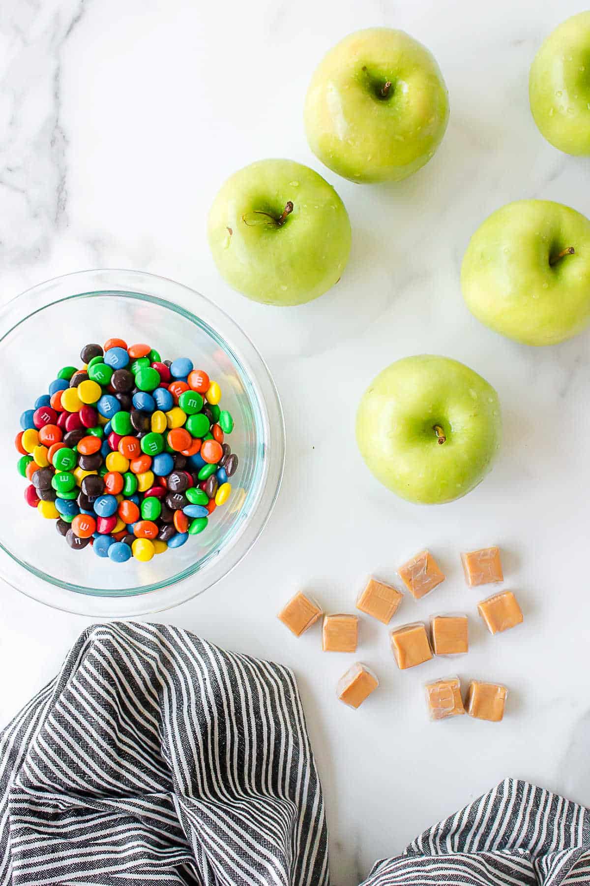 Ingredients for M&M caramel apples in dishes. 