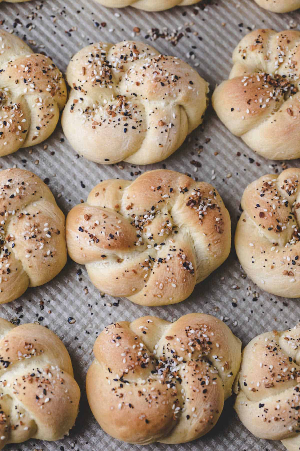Everything bagel knots on a baking sheet. 