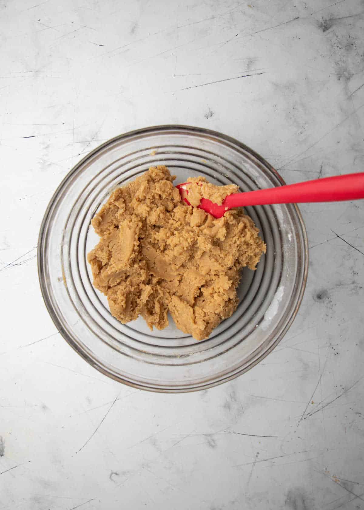 Chocolate chip cookie dough without chocolate chips in it in a mixing bowl.