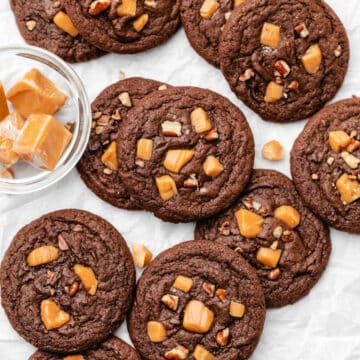 Stacks of turtle cookies on a piece of parchment paper.