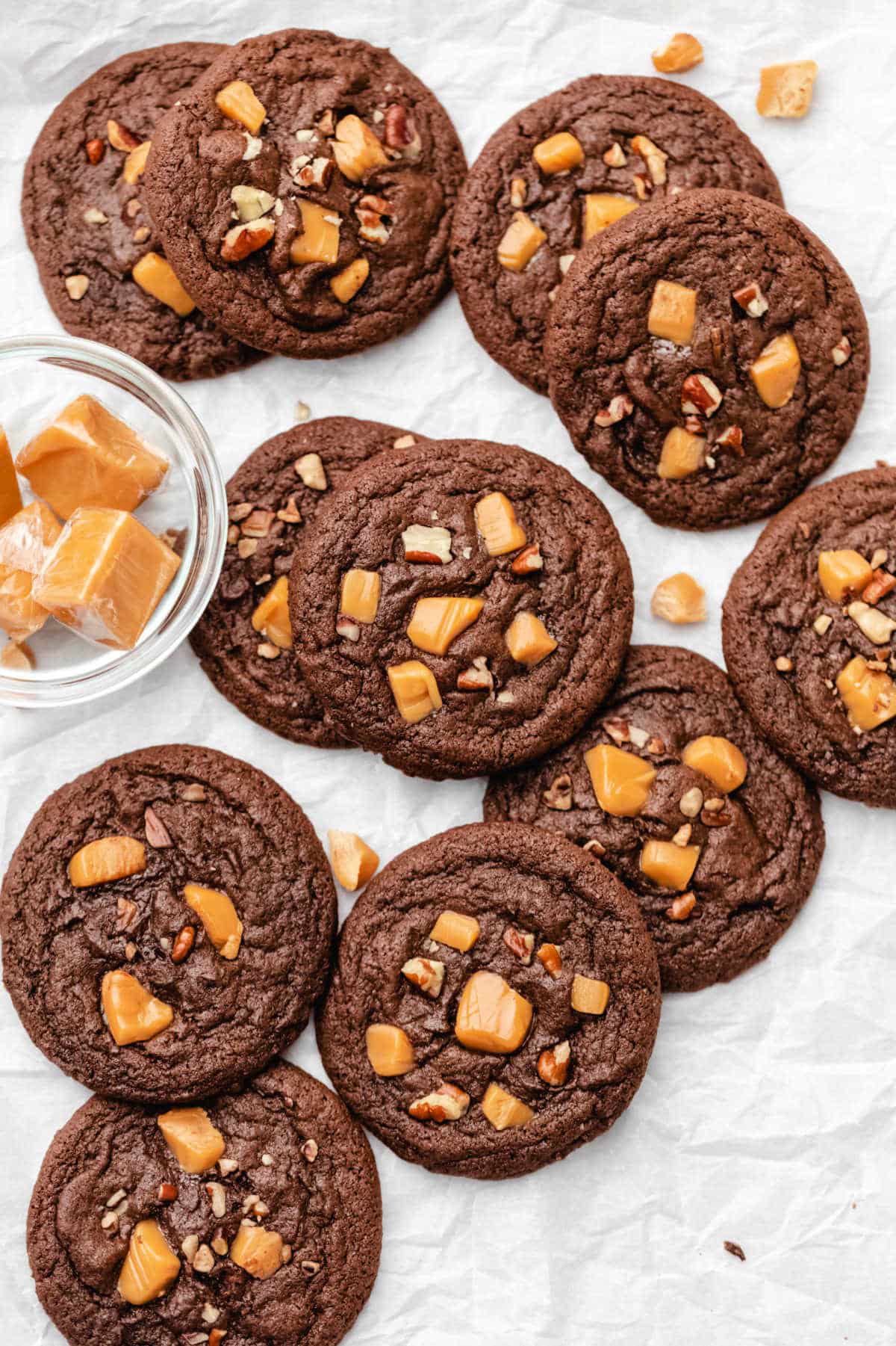 Stacks of turtle cookies on a piece of parchment paper.