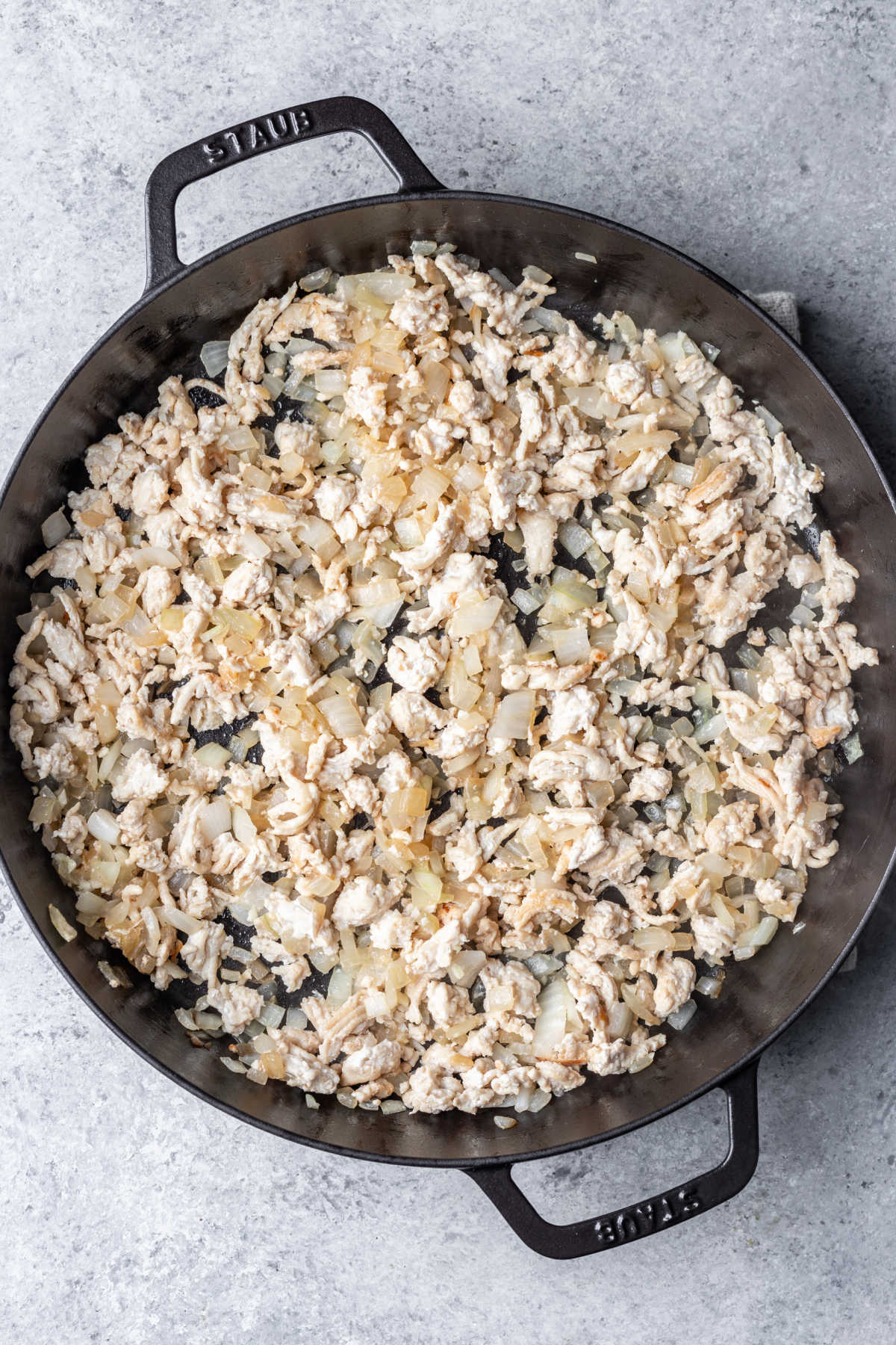 Ground turkey and onion in a cast iron skillet. 