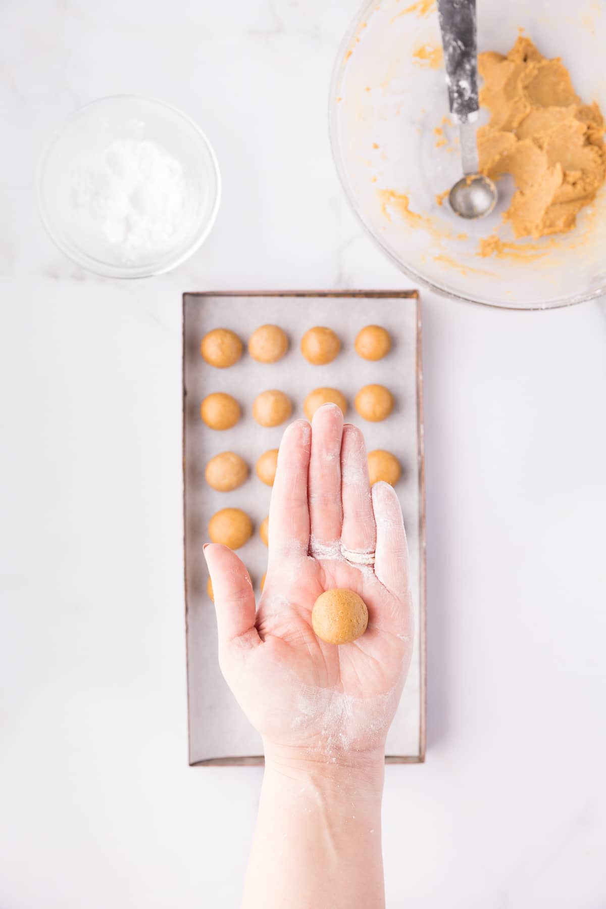 A hand holding a ball of pumpkin pie filling. 