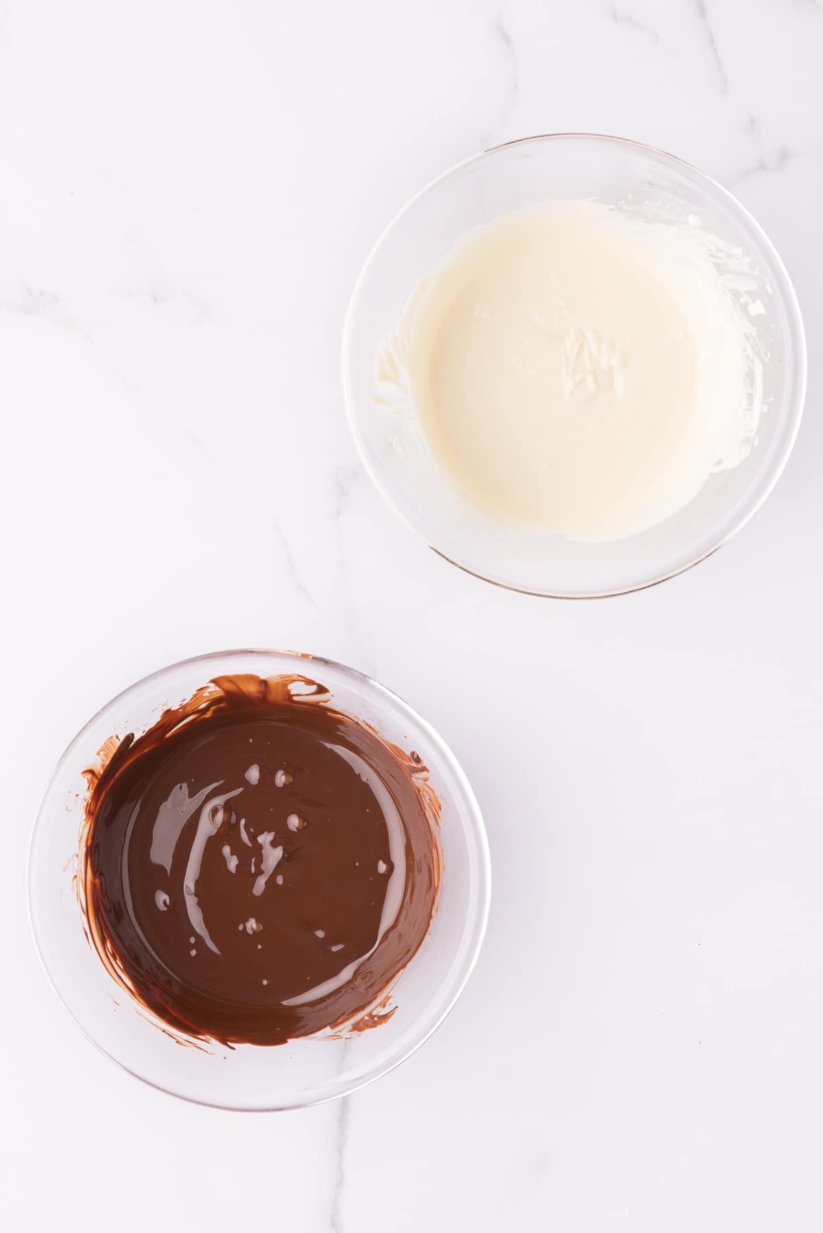 Melted white chocolate and semisweet chocolate in bowls.