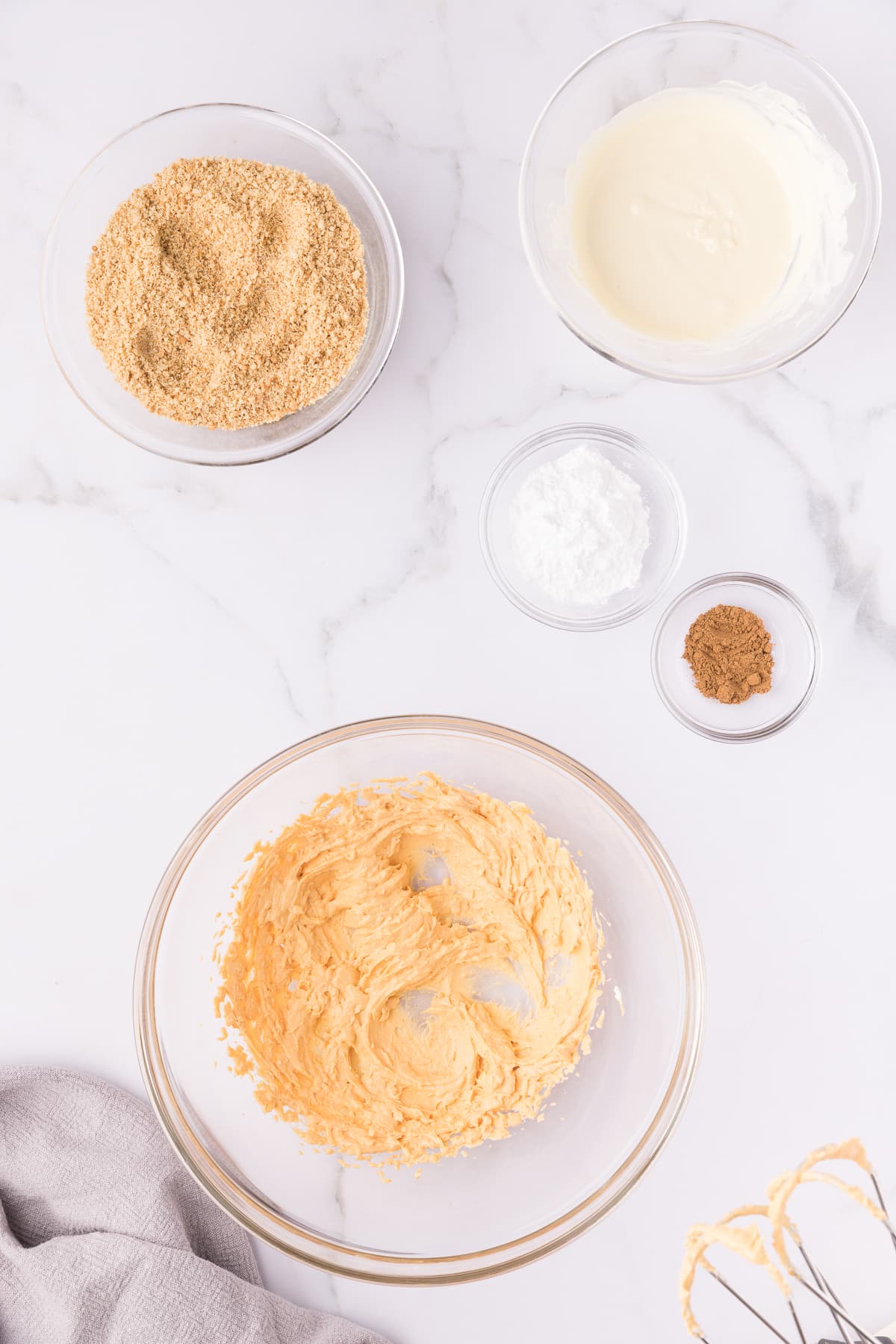 Beaten pumpkin and cream cheese in a glass mixing bowl. 