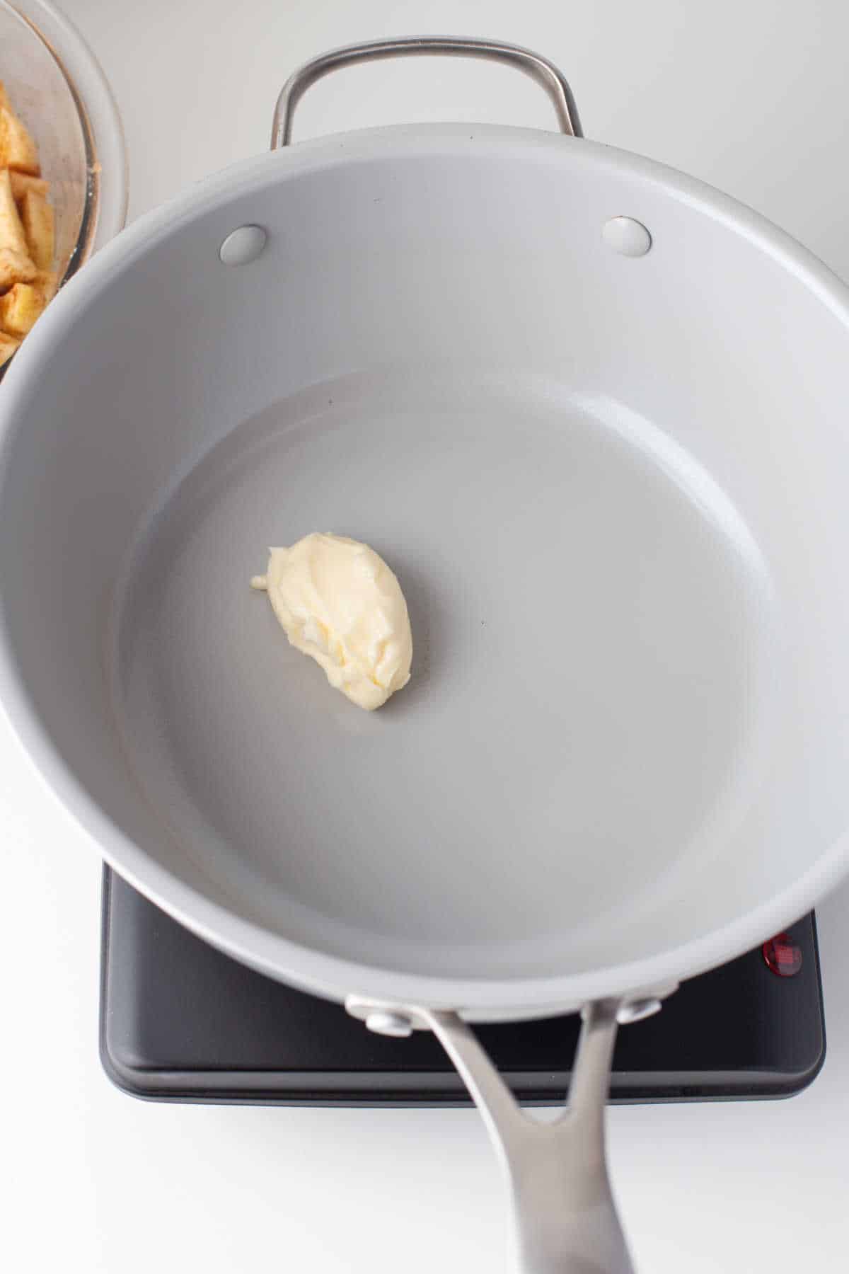 A pat of butter melting in a skillet. 