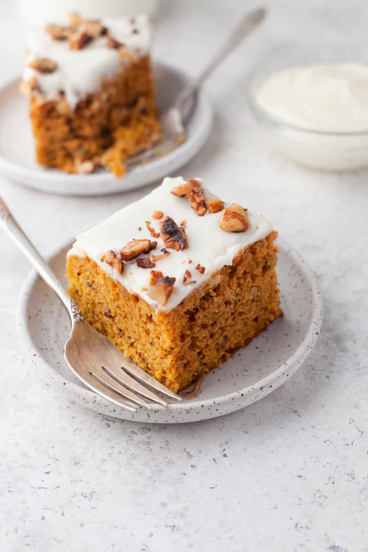 A pumpkin bar on a white plate with a fork on it. 