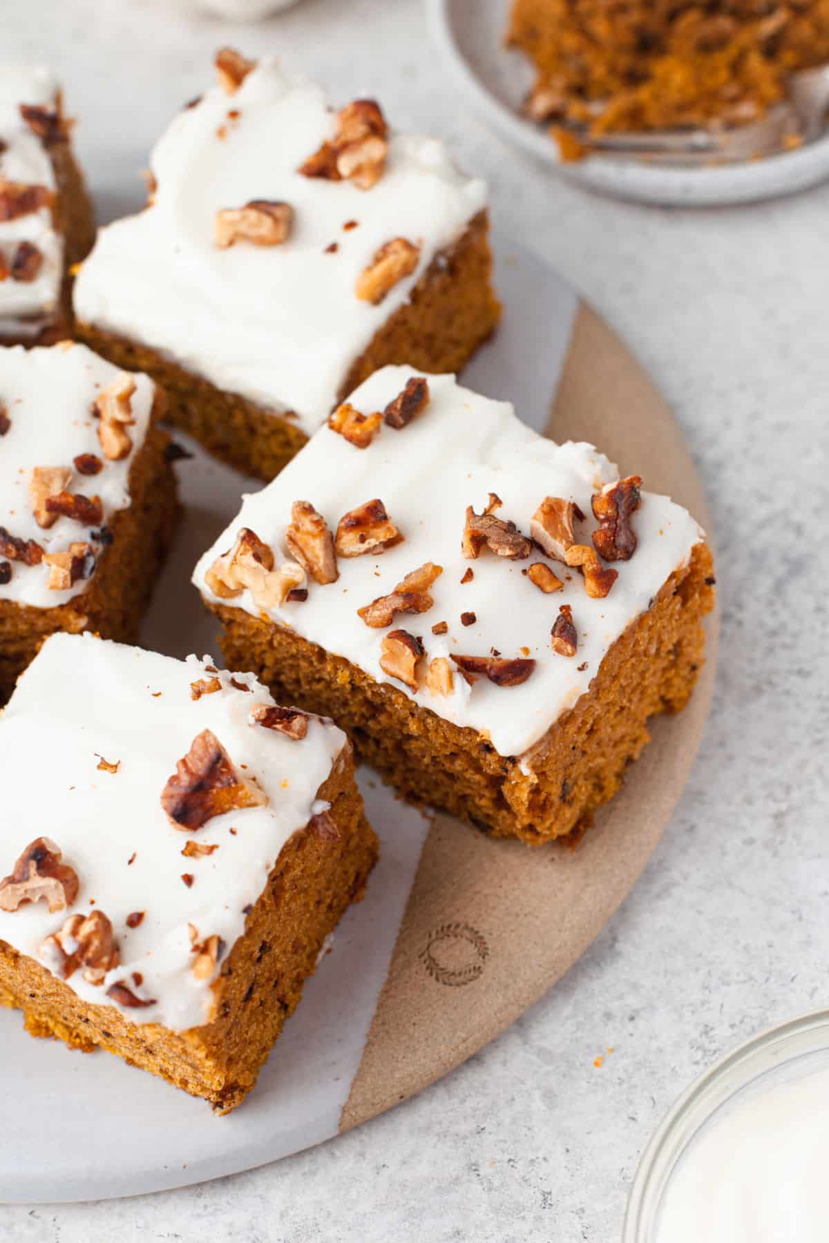 Pumpkin bars on a round wooden cutting board. 