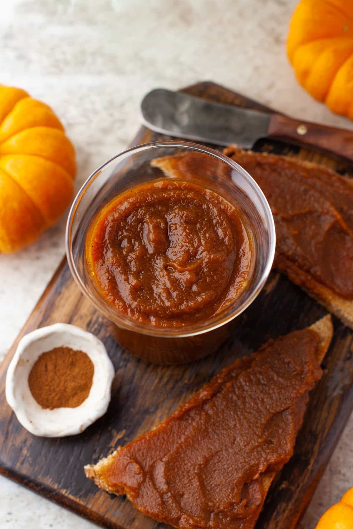 Overhead photo of pumpkin butter next to two pieces of toast with pumpkin butter. 