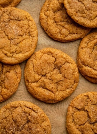 Overlapping pumpkin snickerdoodles on a piece of brown parchment paper.