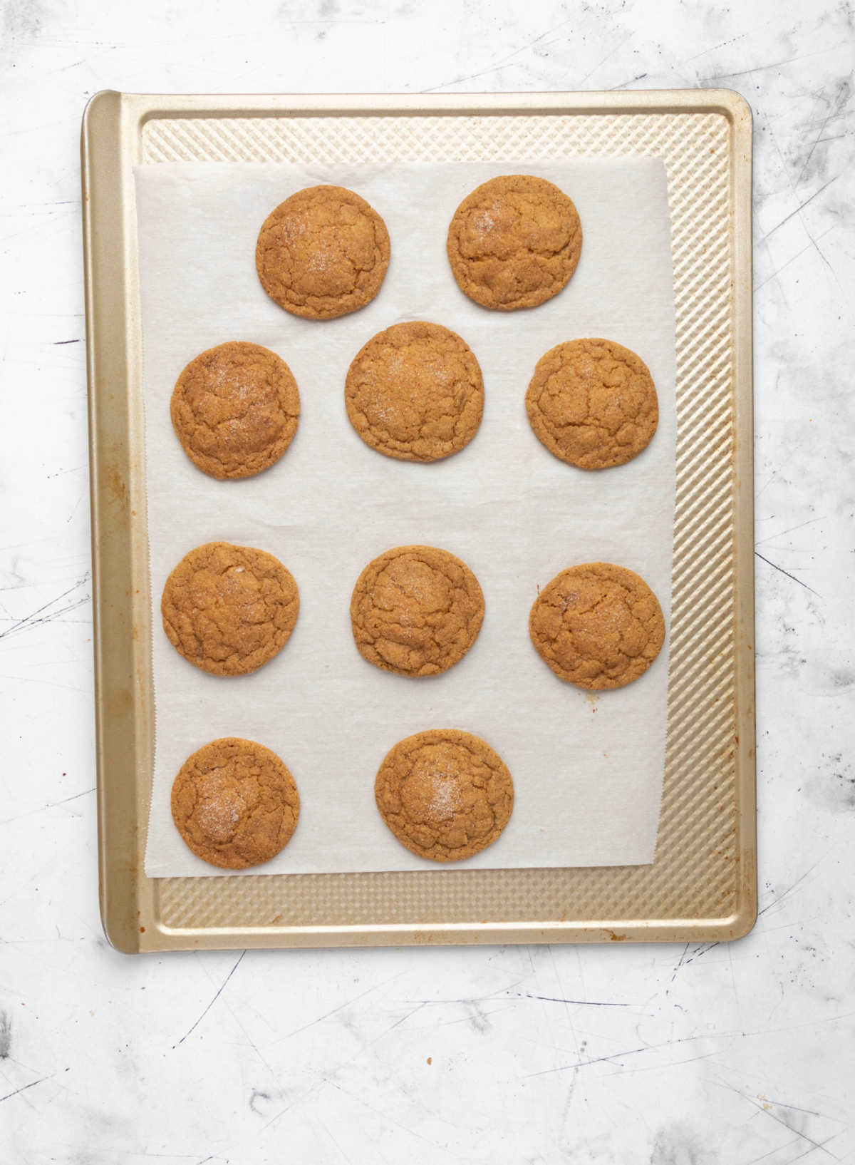 Baked pumpkin snickerdoodles on a baking sheet. 