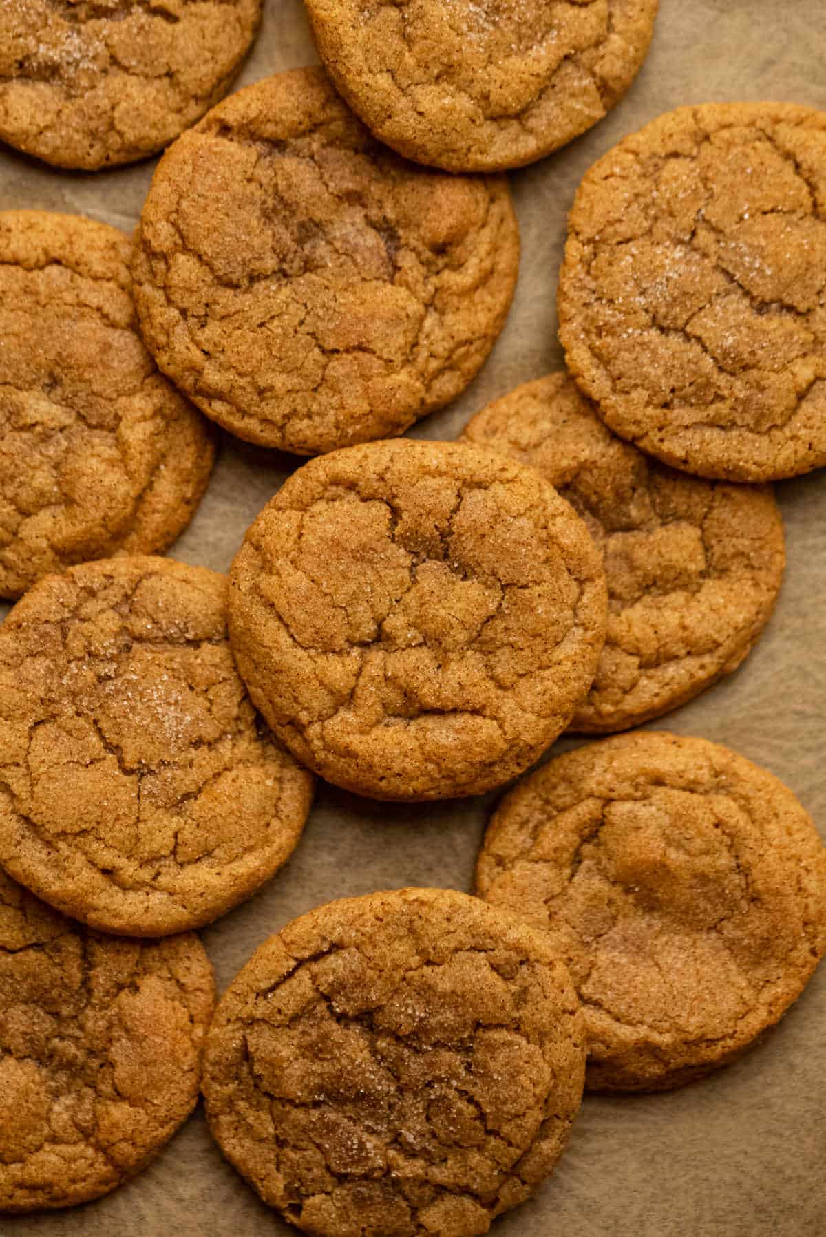 Pumpkin snickerdoodles in low stacks on a piece of parchment paper. 