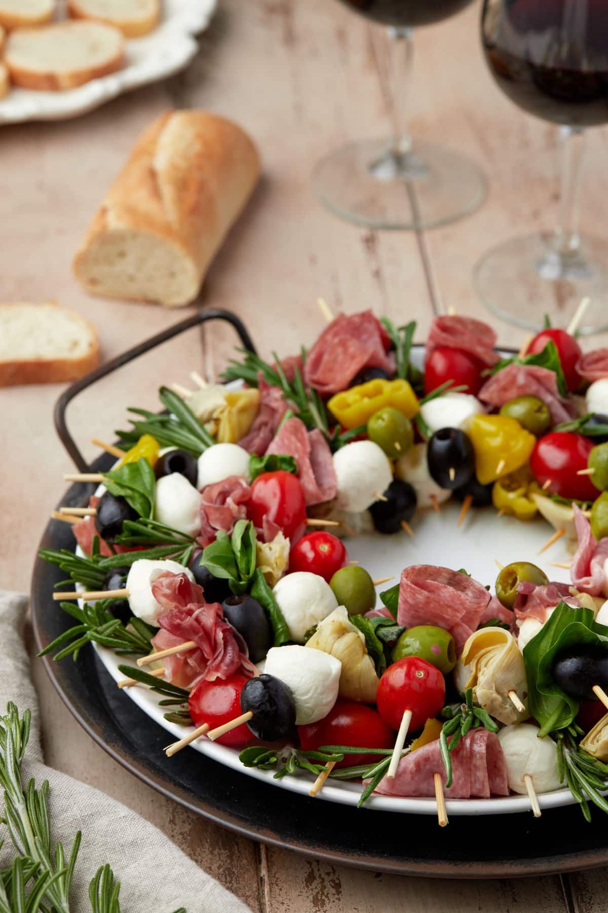 A charcuterie wreath next to baguette slices.