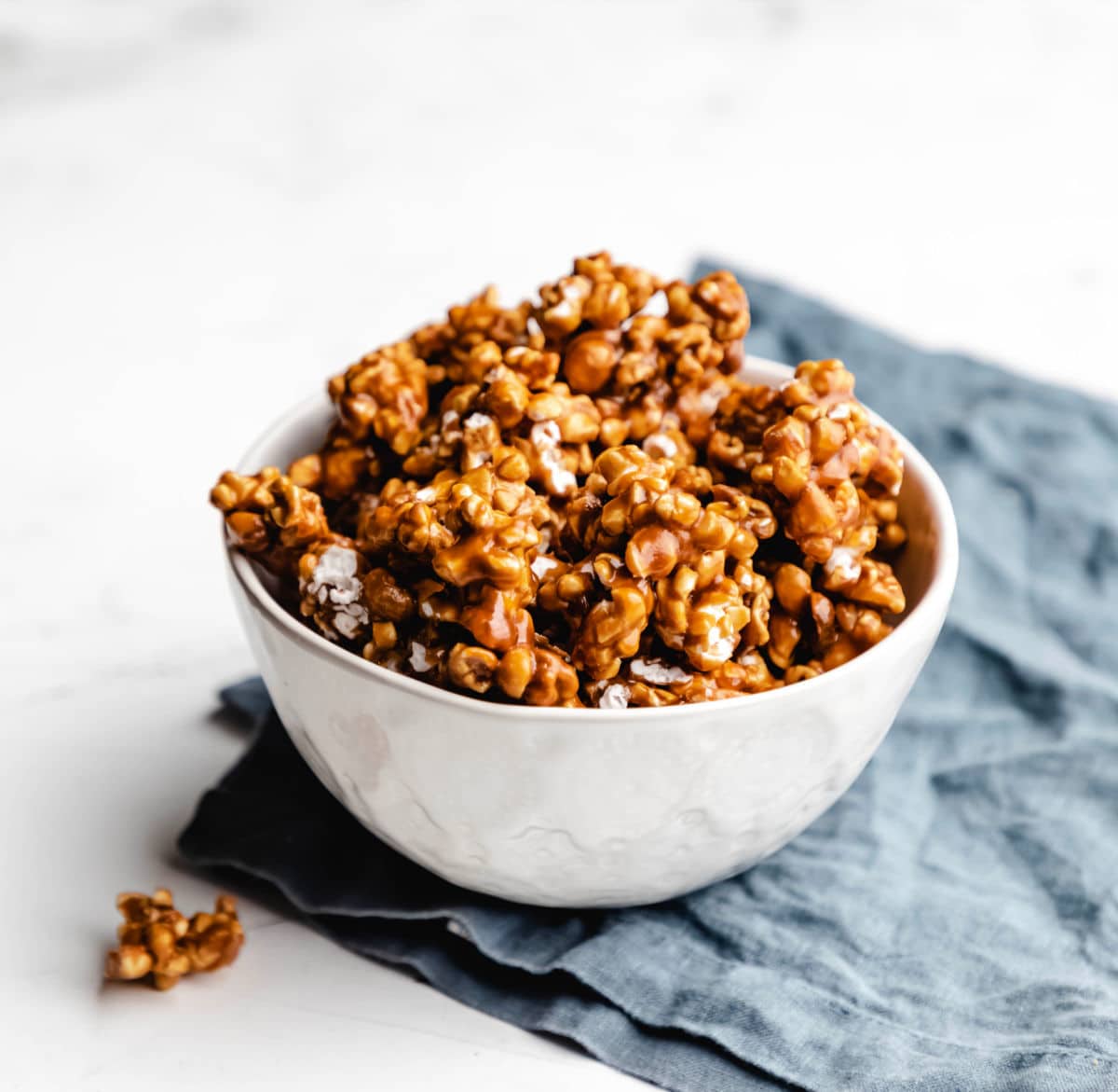 Caramel corn piled up in a white dish. 