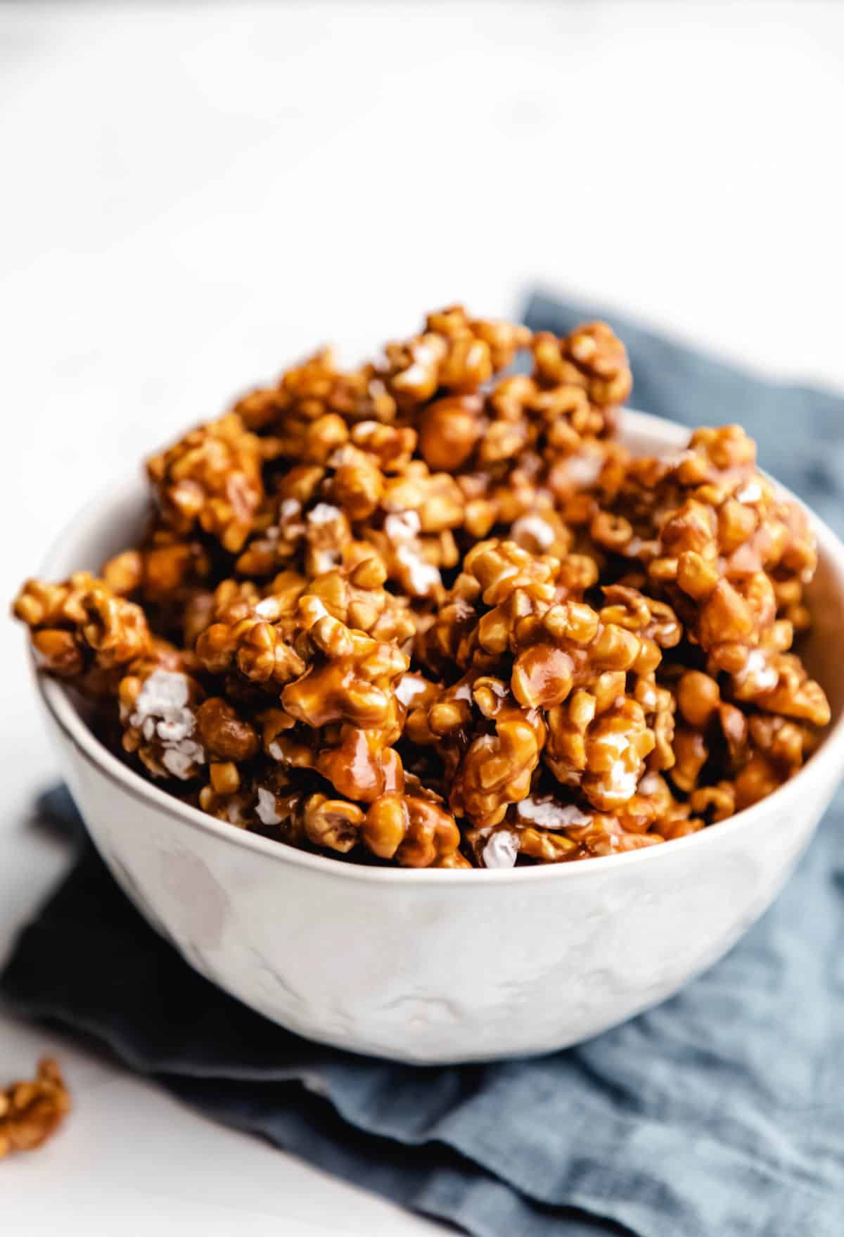 A dish of homemade caramel corn on a blue napkin. 