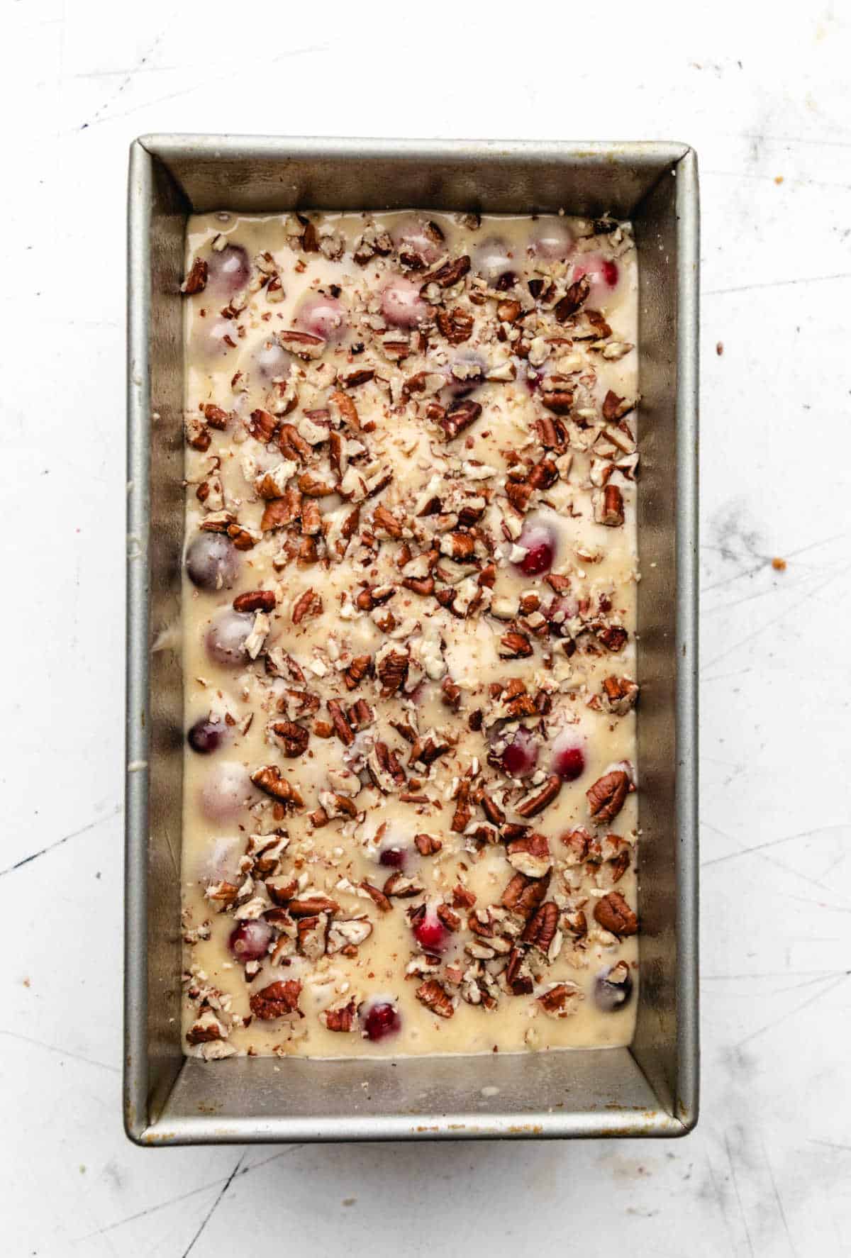 Cranberry nut bread batter in a loaf pan. 