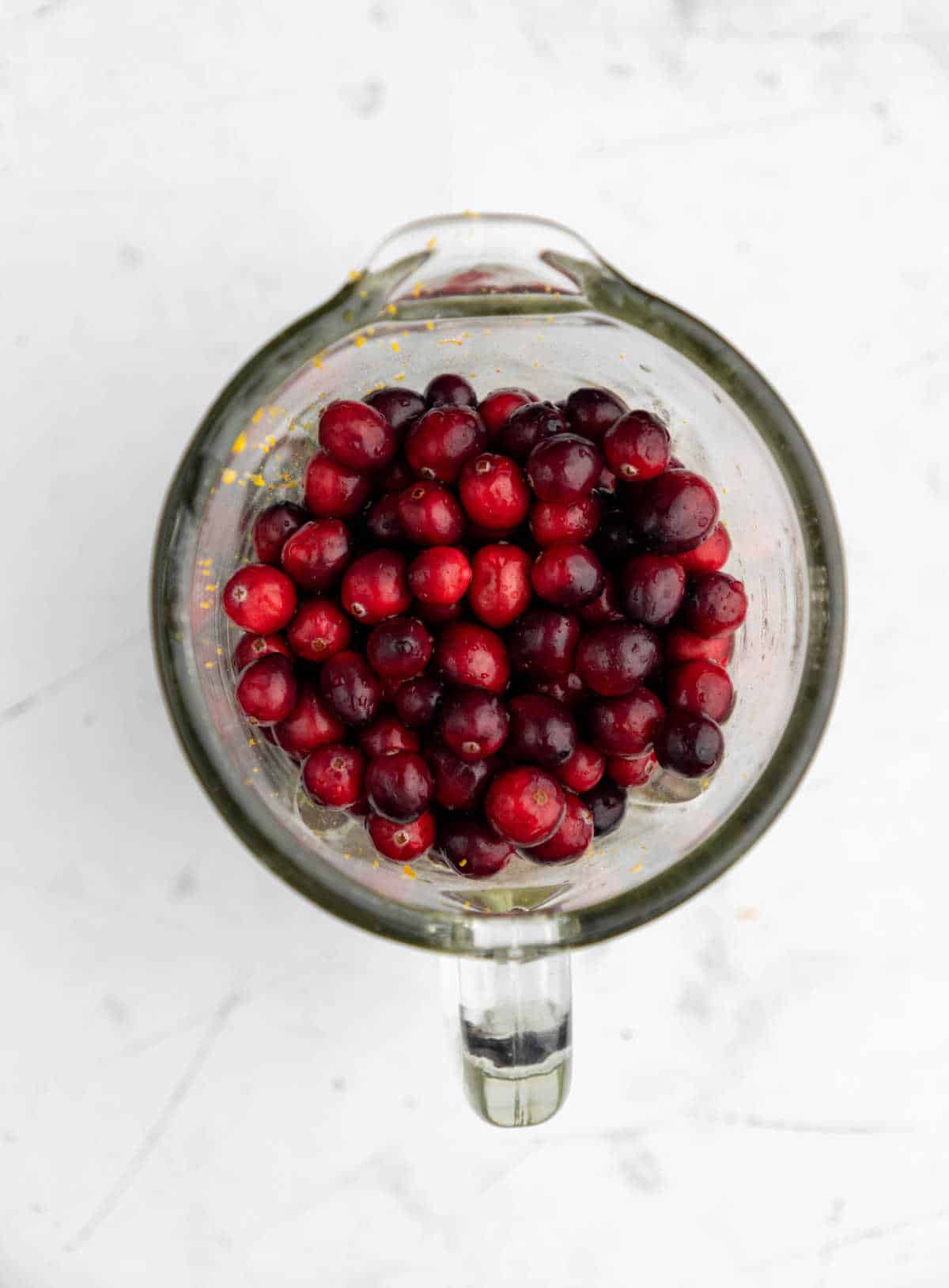 Cranberries in a glass blender bowl.