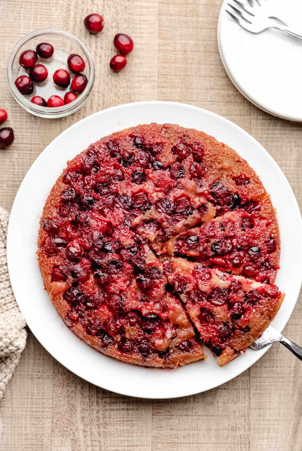 A spatula removing a slice of cranberry upside down cake. 