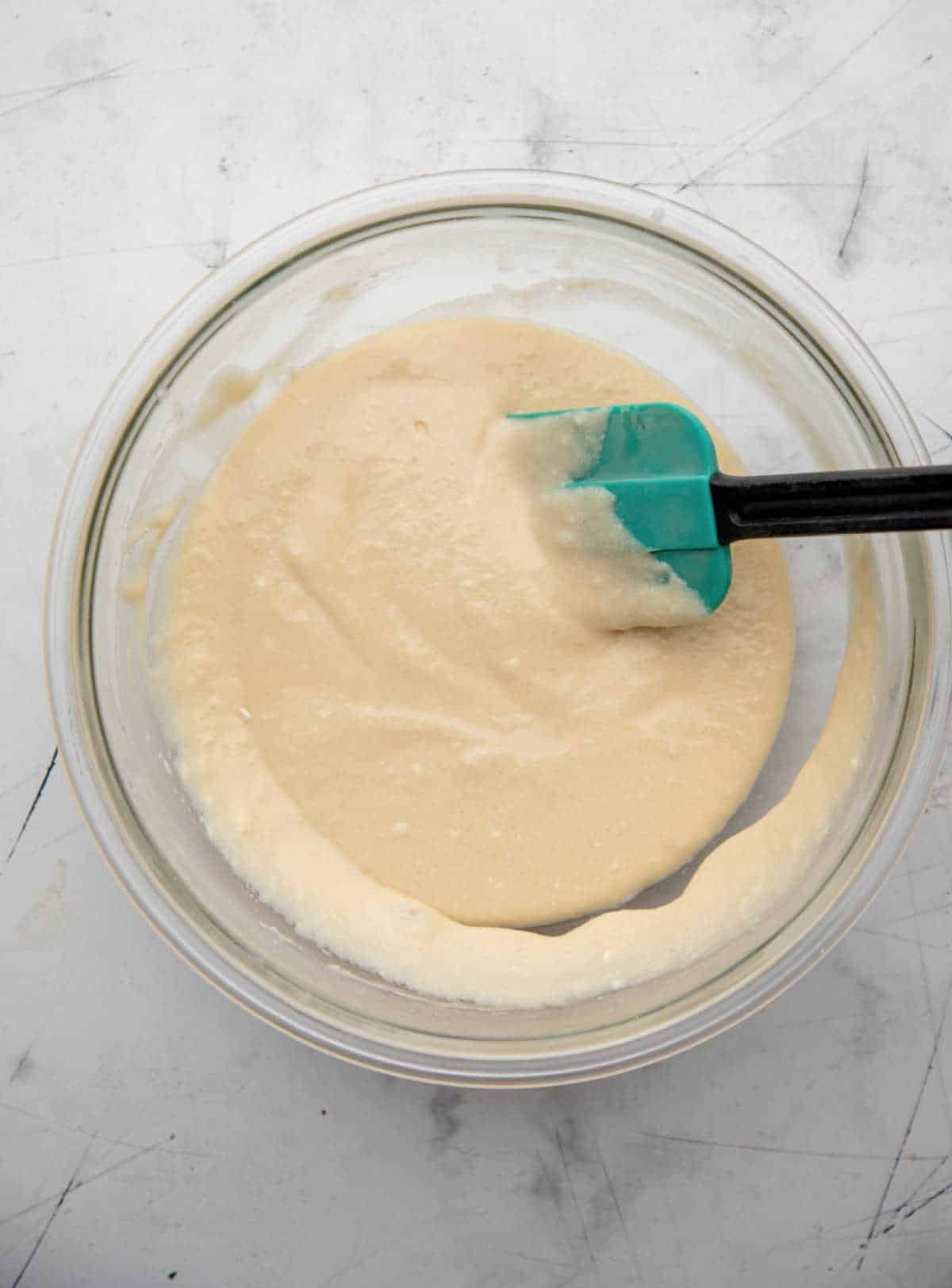 Cranberry upside down cake batter in a glass mixing bowl. 