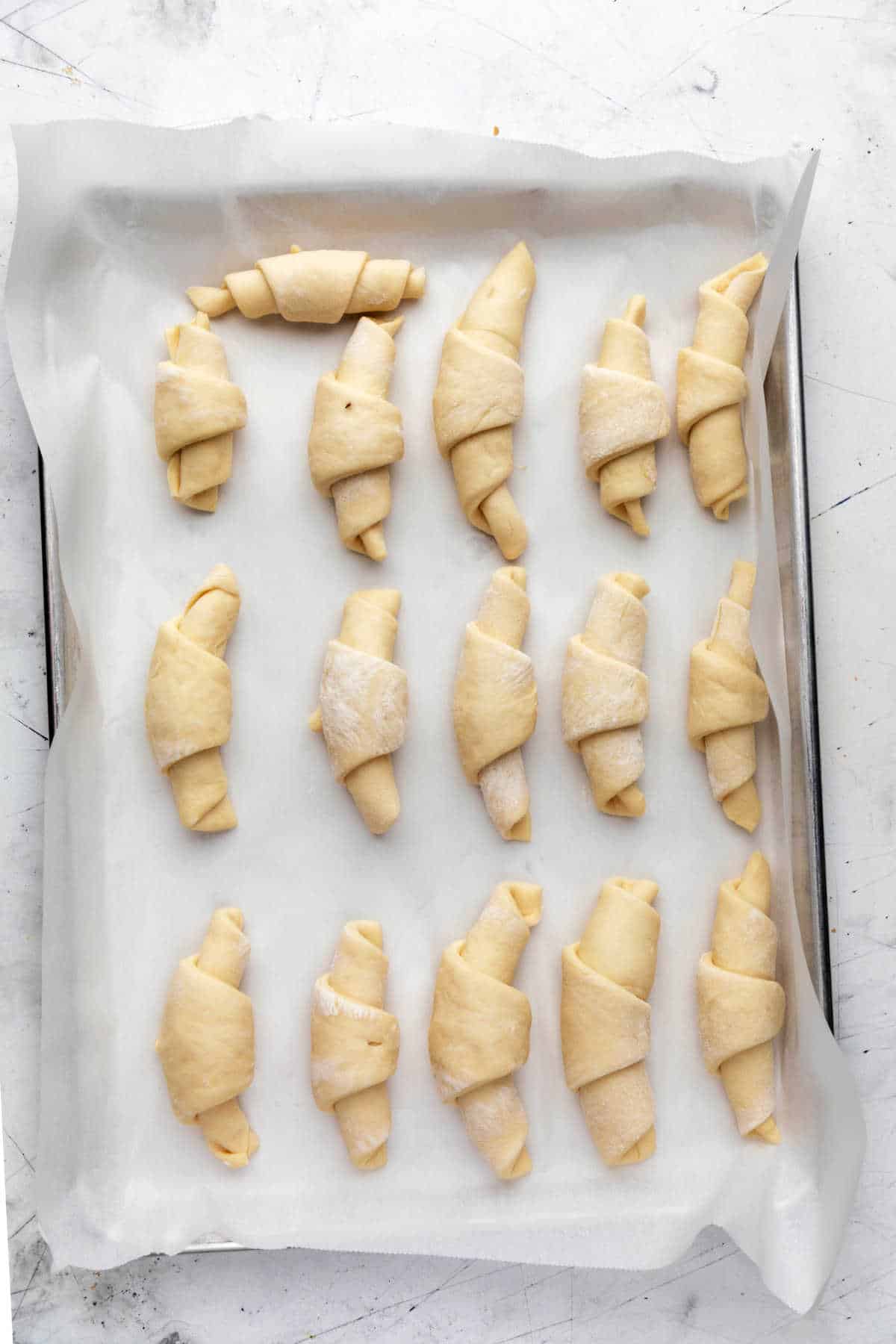 Risen crescent rolls on a baking tray.
