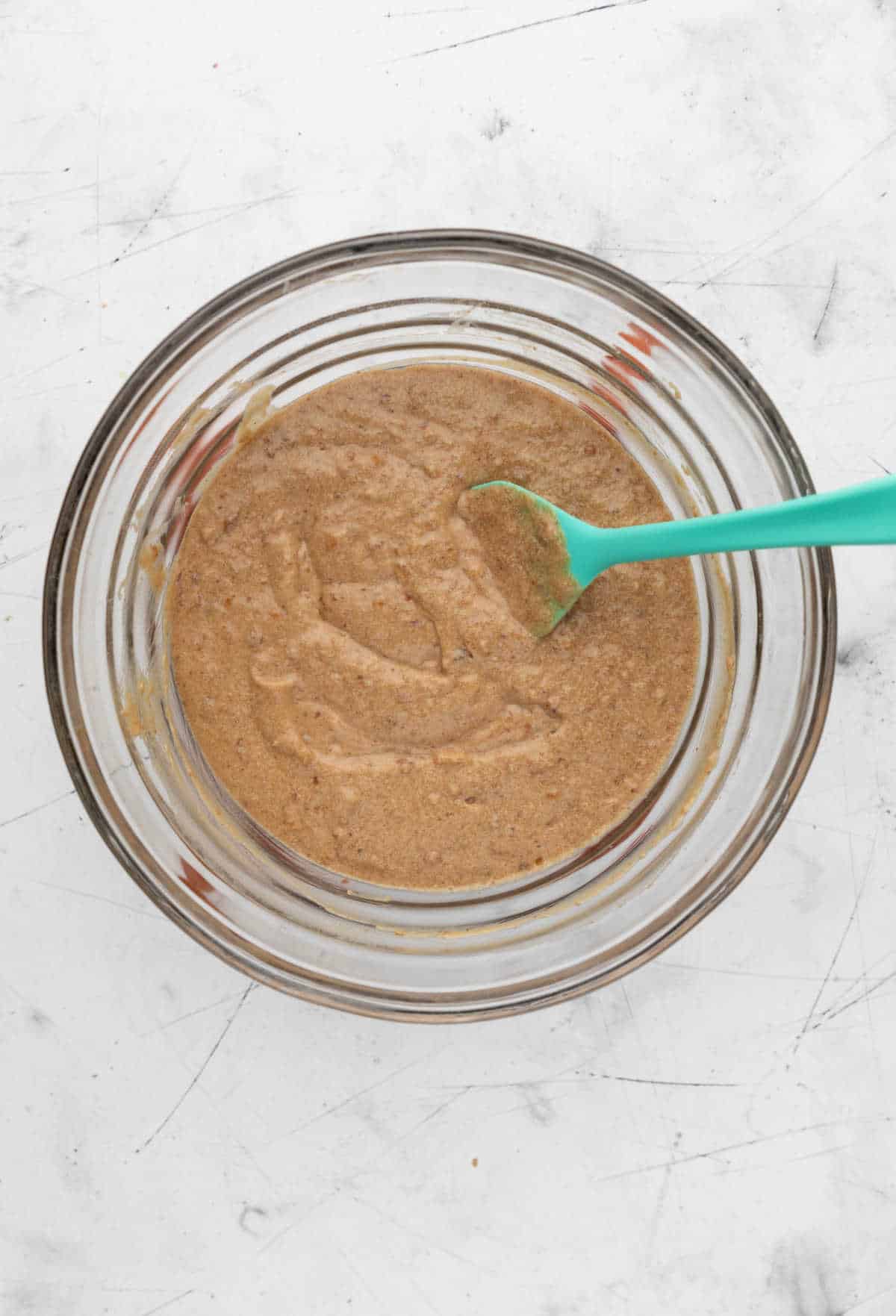 Sticky toffee pudding cake batter in a glass mixing bowl. 