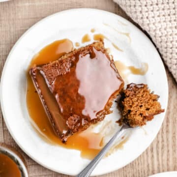 A piece of sticky toffee pudding cake with a bite on a fork.