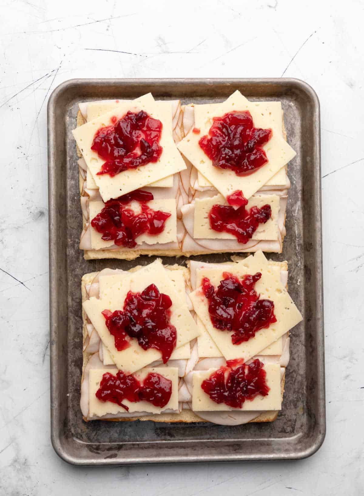 Dollops of cranberry sauce over turkey and cheese. 