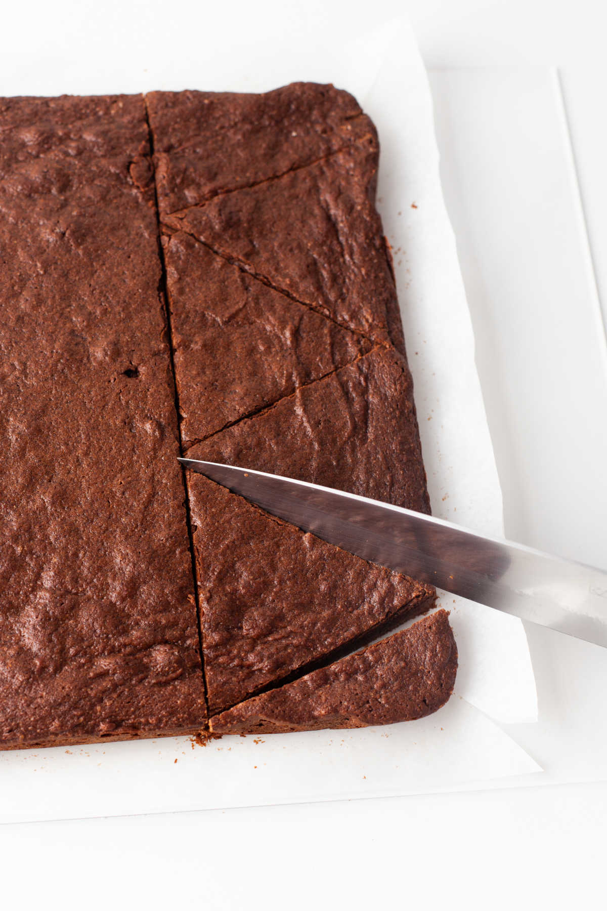 A knife cutting brownies into triangles. 
