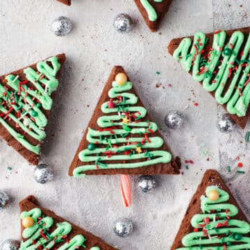 Christmas tree brownies surrounded by silver balls.