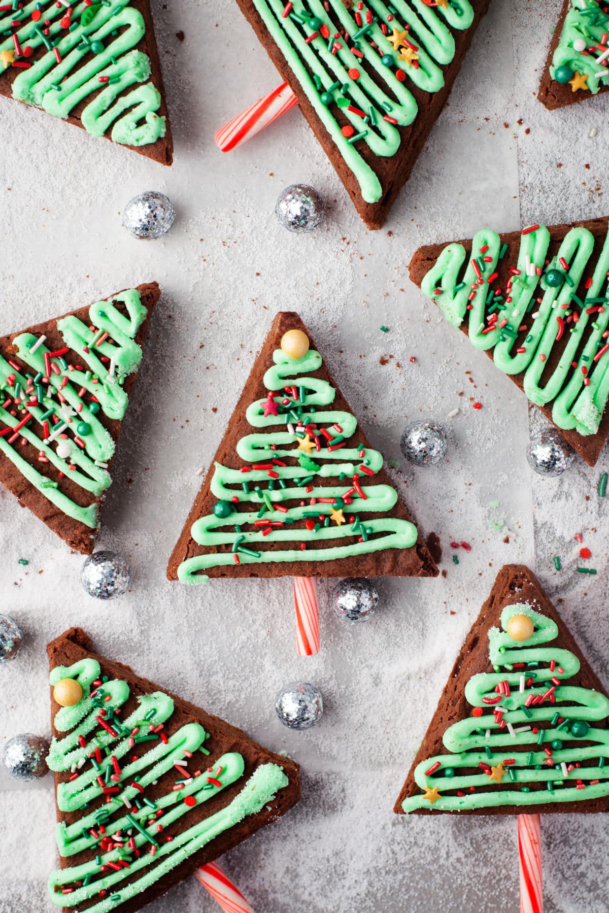 Christmas tree brownies surrounded by silver balls. 