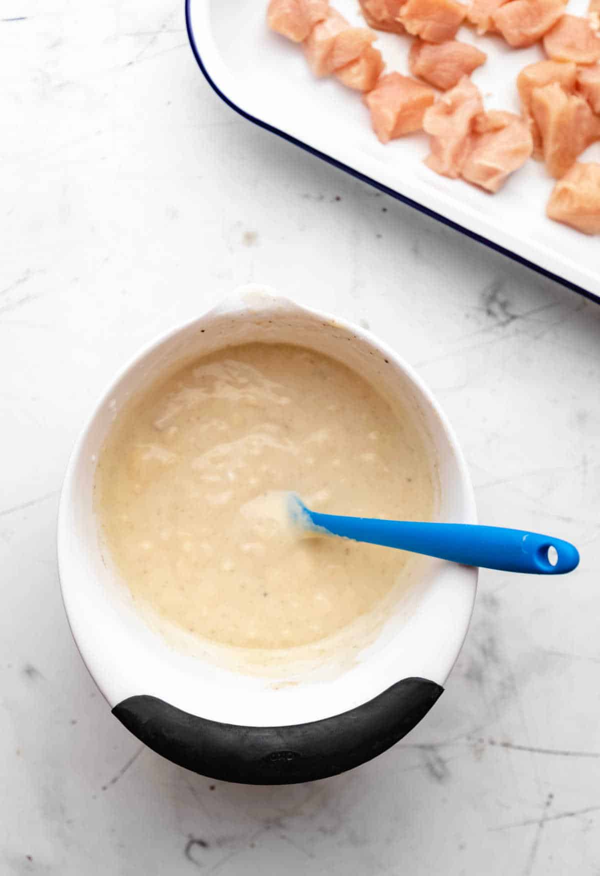 Condensed soup sour cream and milk in a white mixing bowl. 