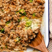 A wooden spoon scooping up chicken broccoli stuffing casserole.