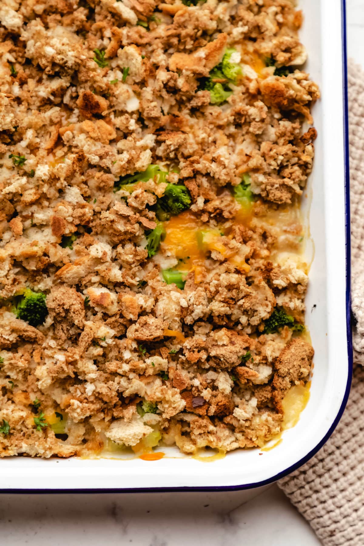 A close up photo of chicken broccoli stuffing casserole in a white baking dish.