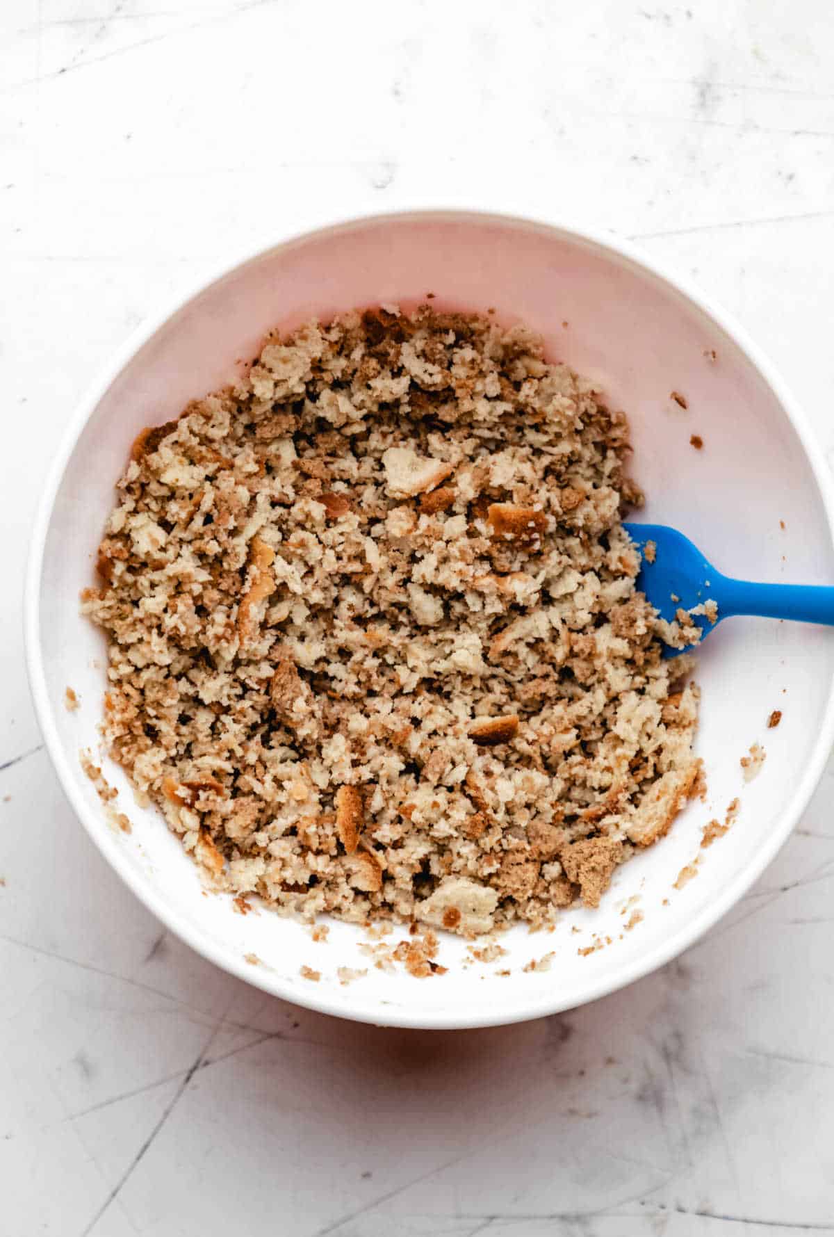 Stuffing mix and broth in a white mixing bowl. 