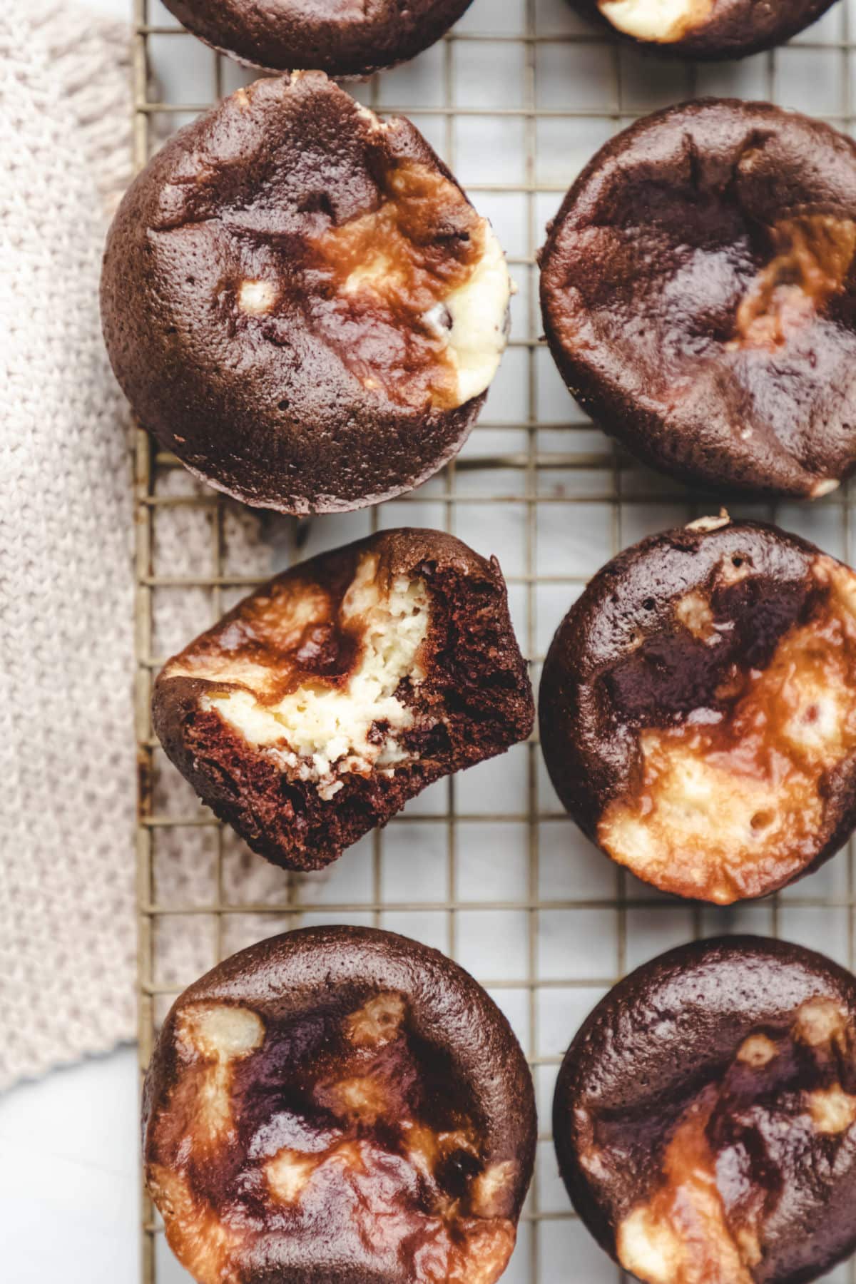 Half of a chocolate cheesecake cupcake in a row of cupcakes.