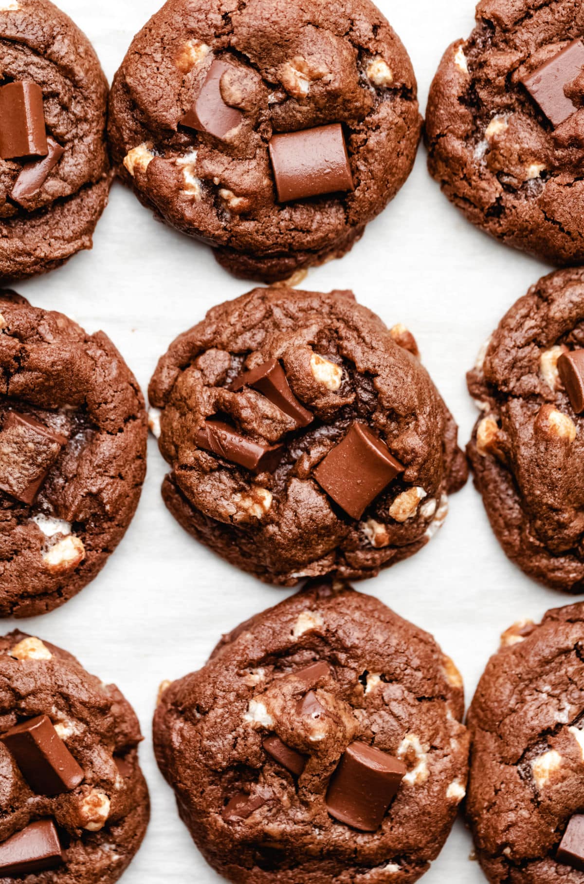 Nine hot chocolate cookies on a piece of parchment paper.