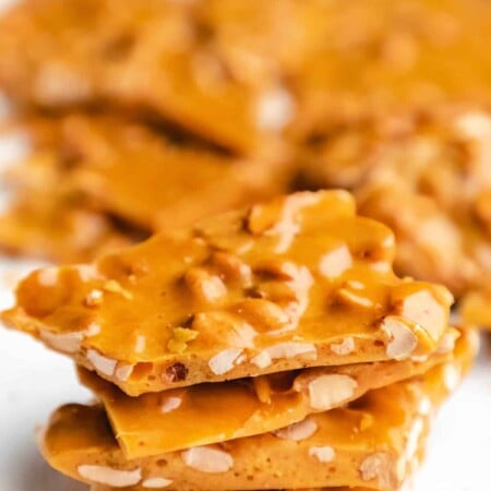 A stack of peanut brittle on a piece of parchment paper.