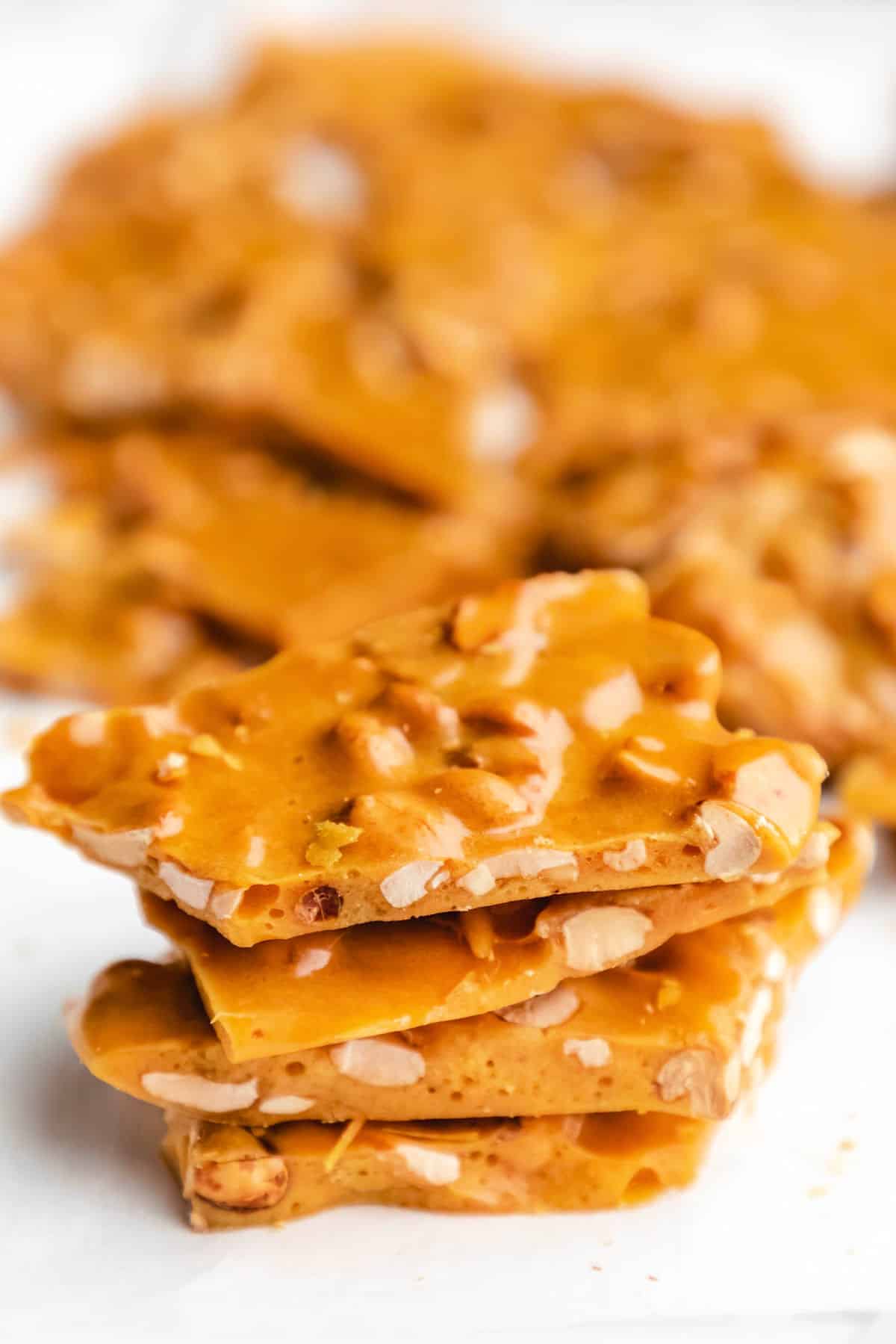 A stack of peanut brittle on a piece of parchment paper. 