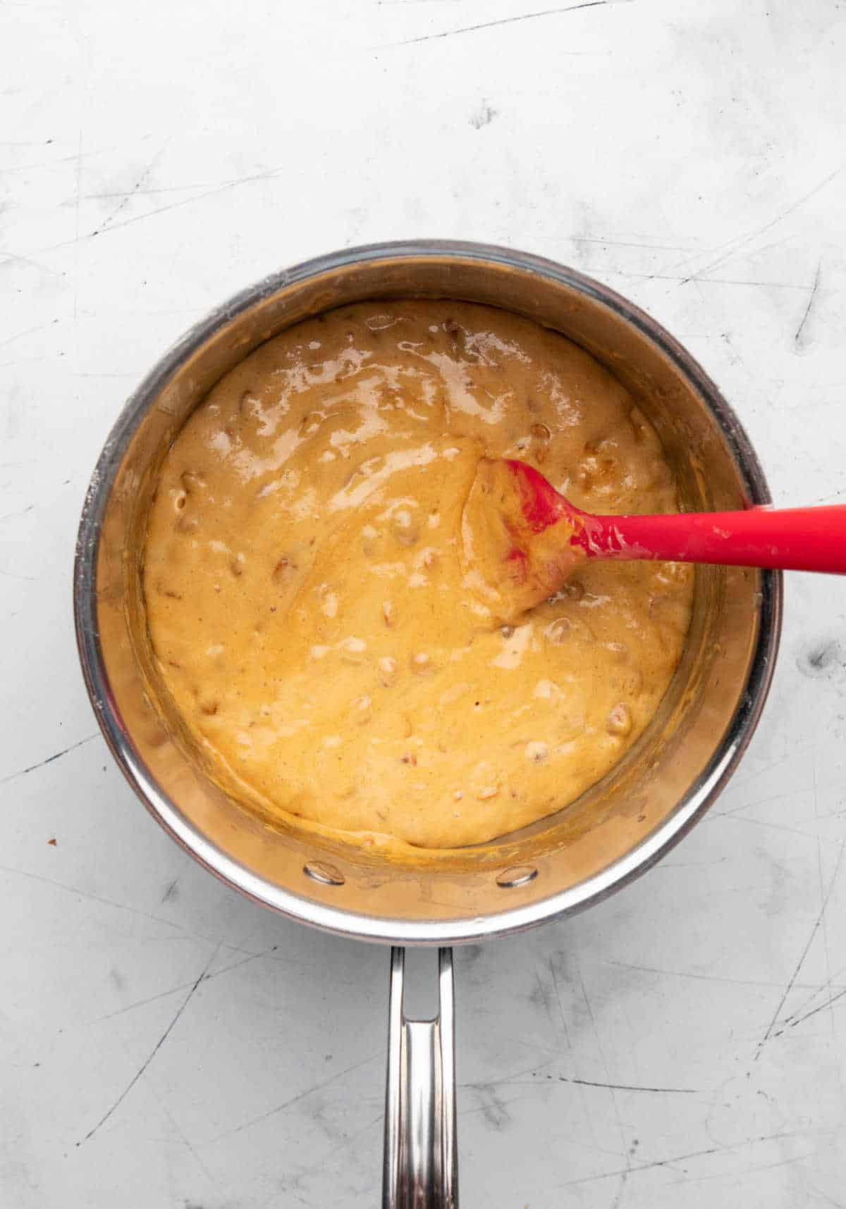 Foamy peanut brittle mixture in a saucepan.