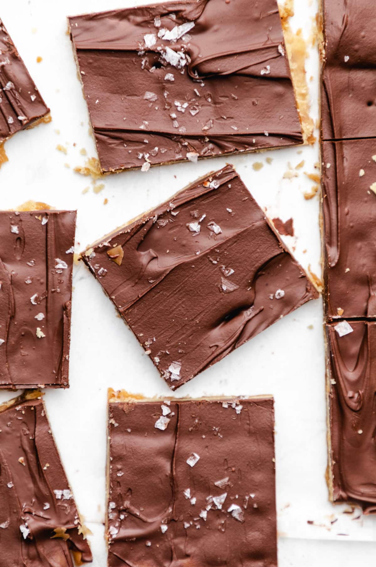 Pieces of saltine toffee on parchment paper. 
