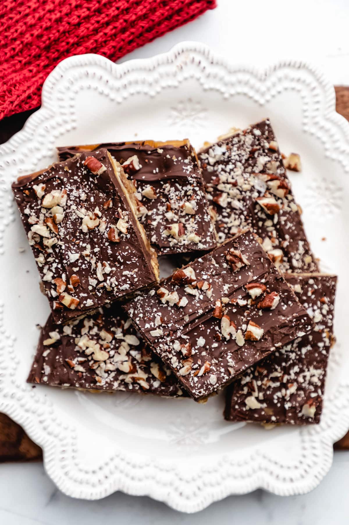 Pieces of saltine toffee on a white plate. 