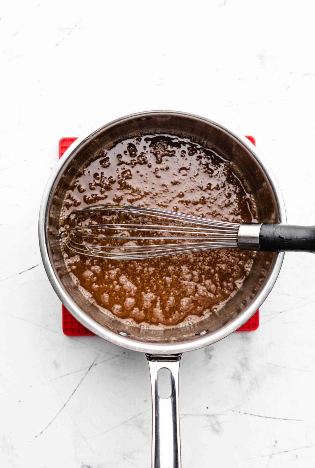 Butter and brown sugar mixture boiling in a saucepan.