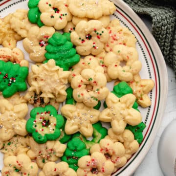 A plate of spritz cookies next to a green knit napkin.