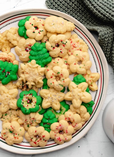 A plate of spritz cookies next to a green knit napkin.