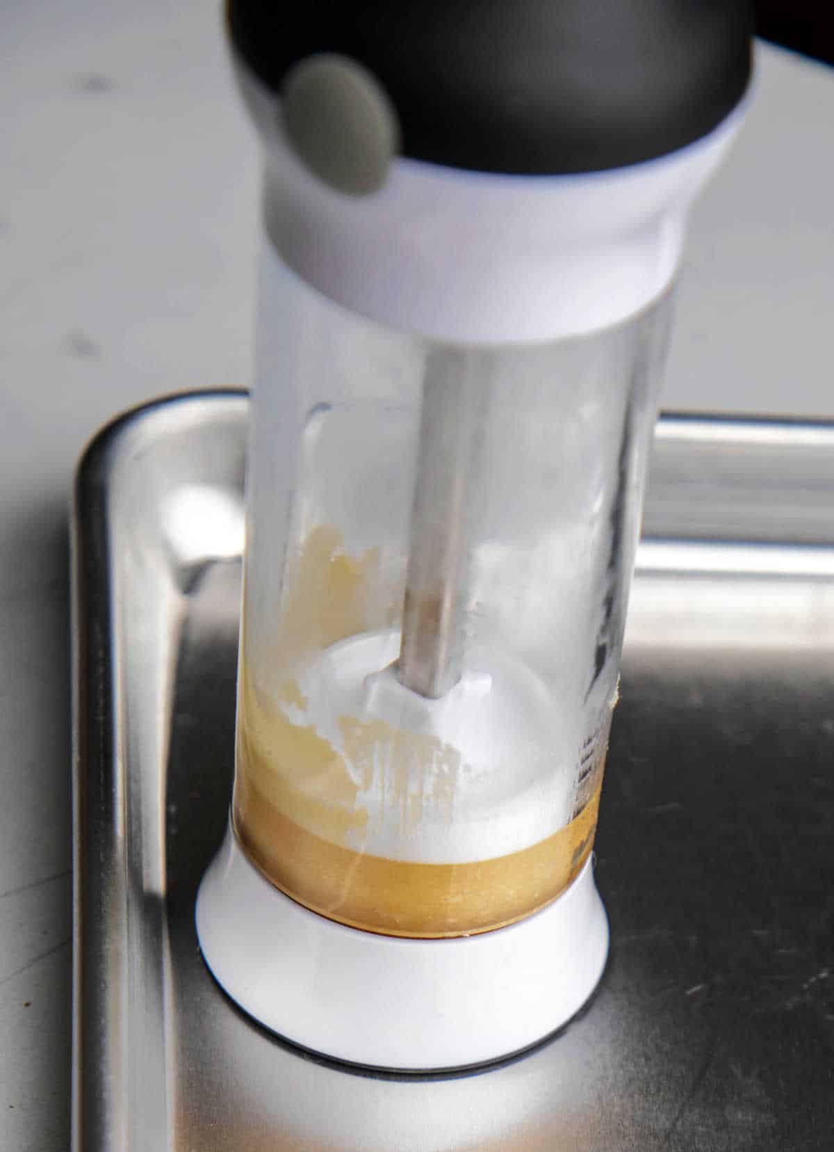 A cookie press on a silver baking sheet. 