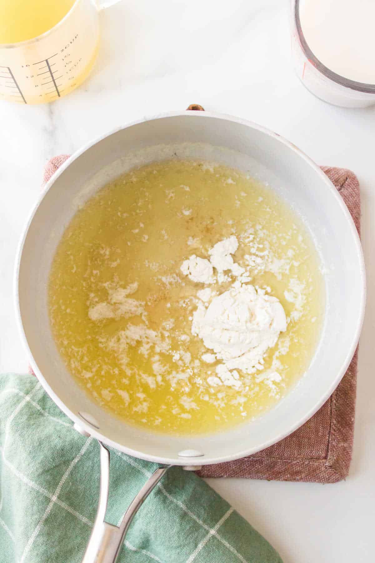 Flour sprinkled over melted butter in a saucepan.