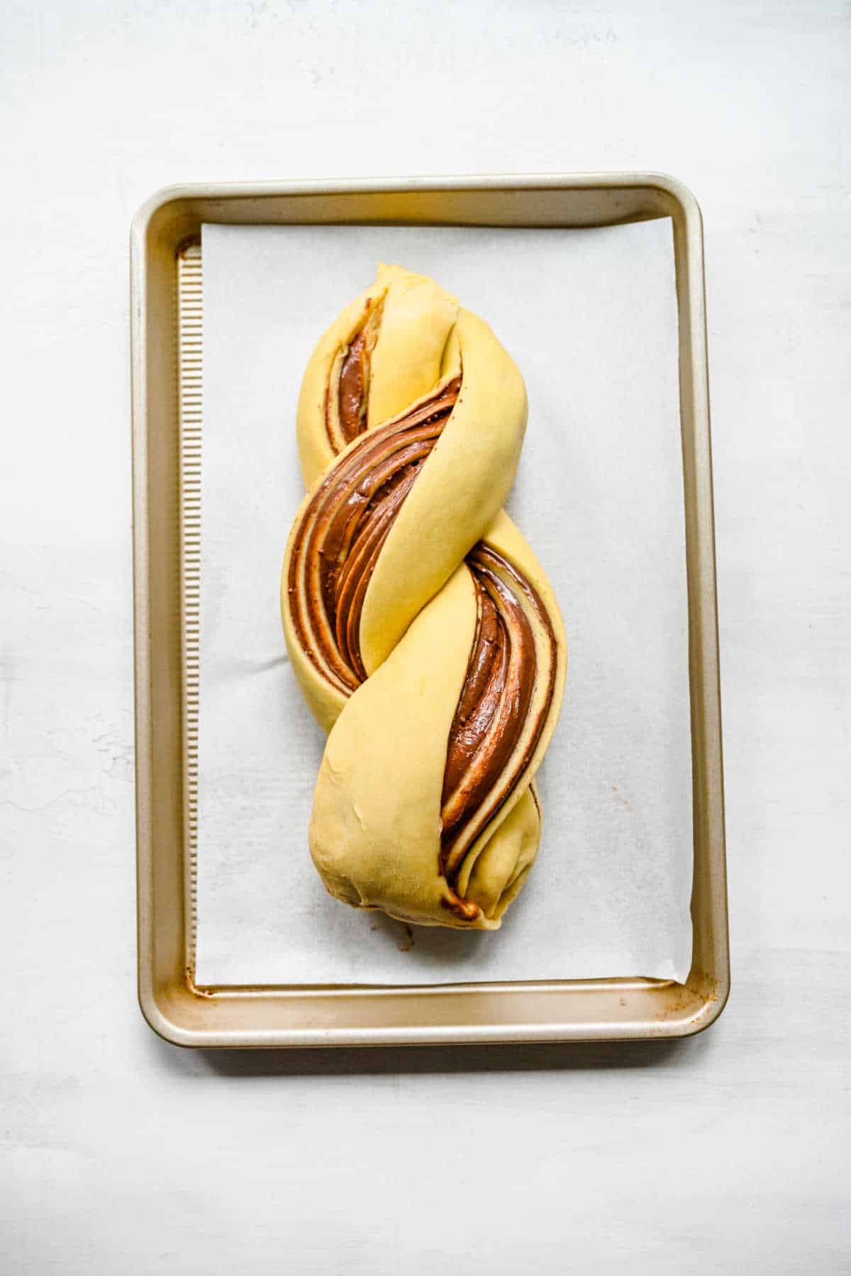 A loaf of unbaked nutella bread dough on a baking sheet. 