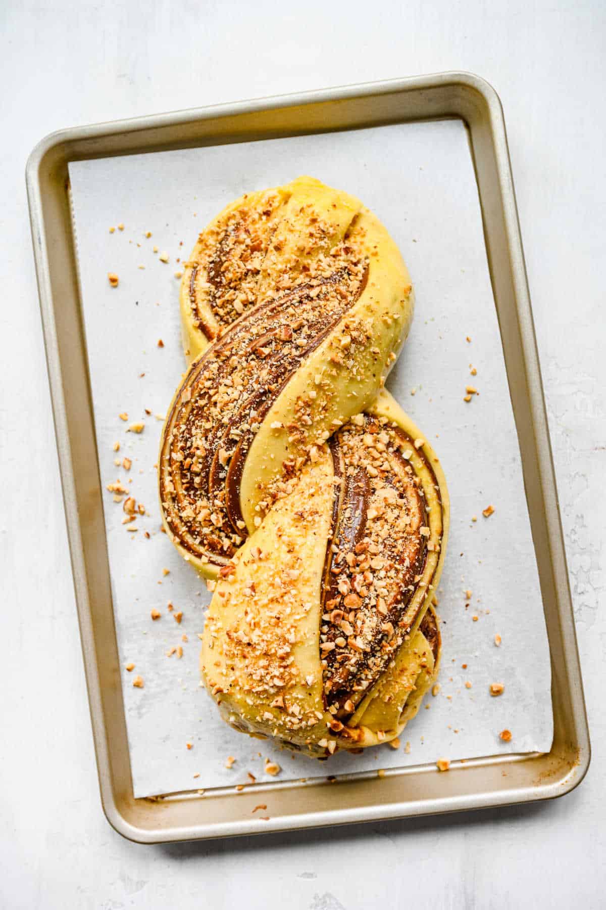 Unbaked Nutella bread topped with chopped hazelnuts. 