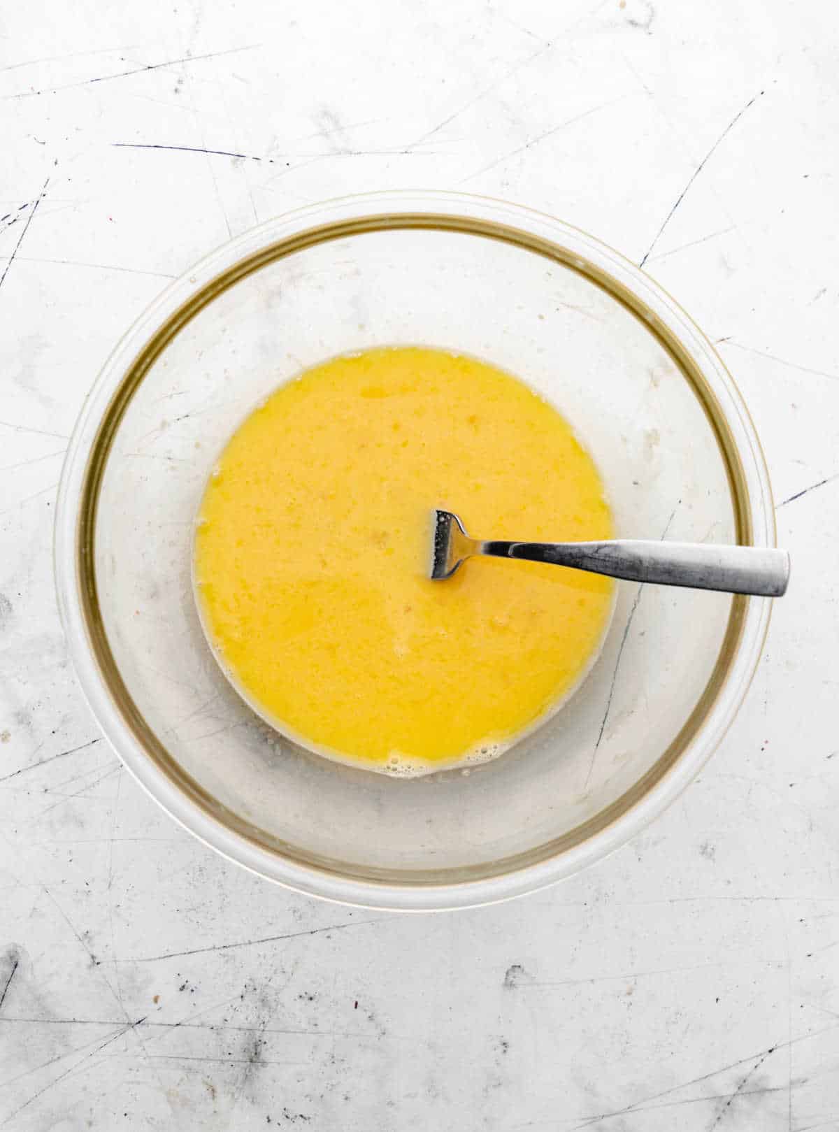 Egg mixture in a glass mixing bowl.