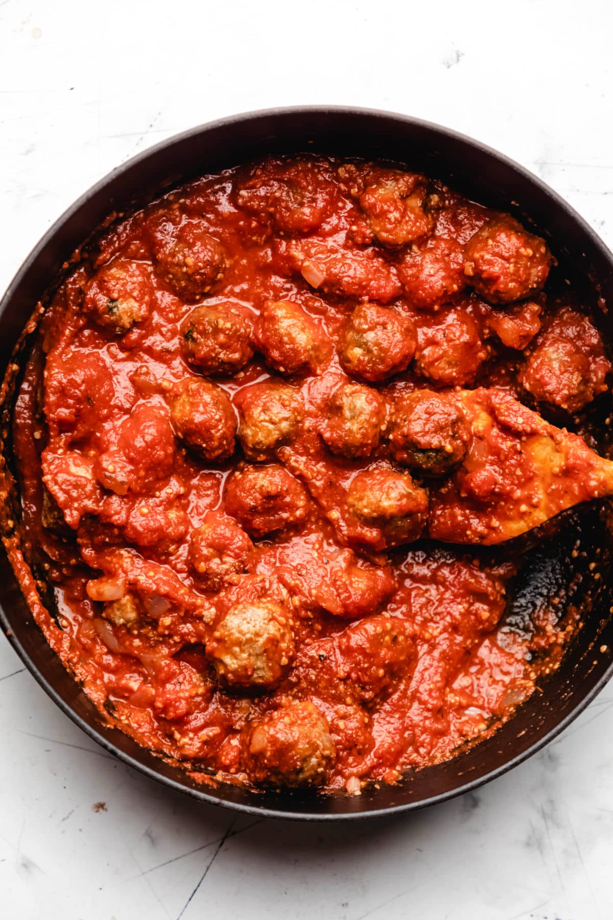 Baked meatballs in tomato sauce in a skillet.
